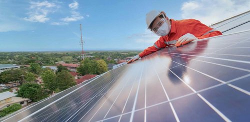 Ein Mann der eine Photovoltaikanlage montiert
